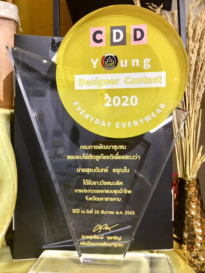 อธิบดีกรมการพัฒนาชุมชน มอบโล่เชิดชูเกียรติแก่นายสุรบดินทร์ อรุณโน ซึ่งเป็นผู้ชนะเลิศการกวดนักออกแบบรุ่นใหม่ (Young Designer )จังหวัดมหาสารคาม
